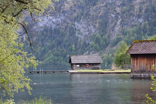 Free Peaceful lakeside scene in Mondsee, Austria, featuring rustic wooden buildings and lush greenery. Stock Photo
