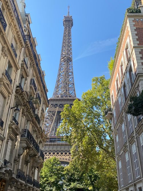 Free The Eiffel Tower seen between historic Parisian buildings, ideal for travel inspiration. Stock Photo