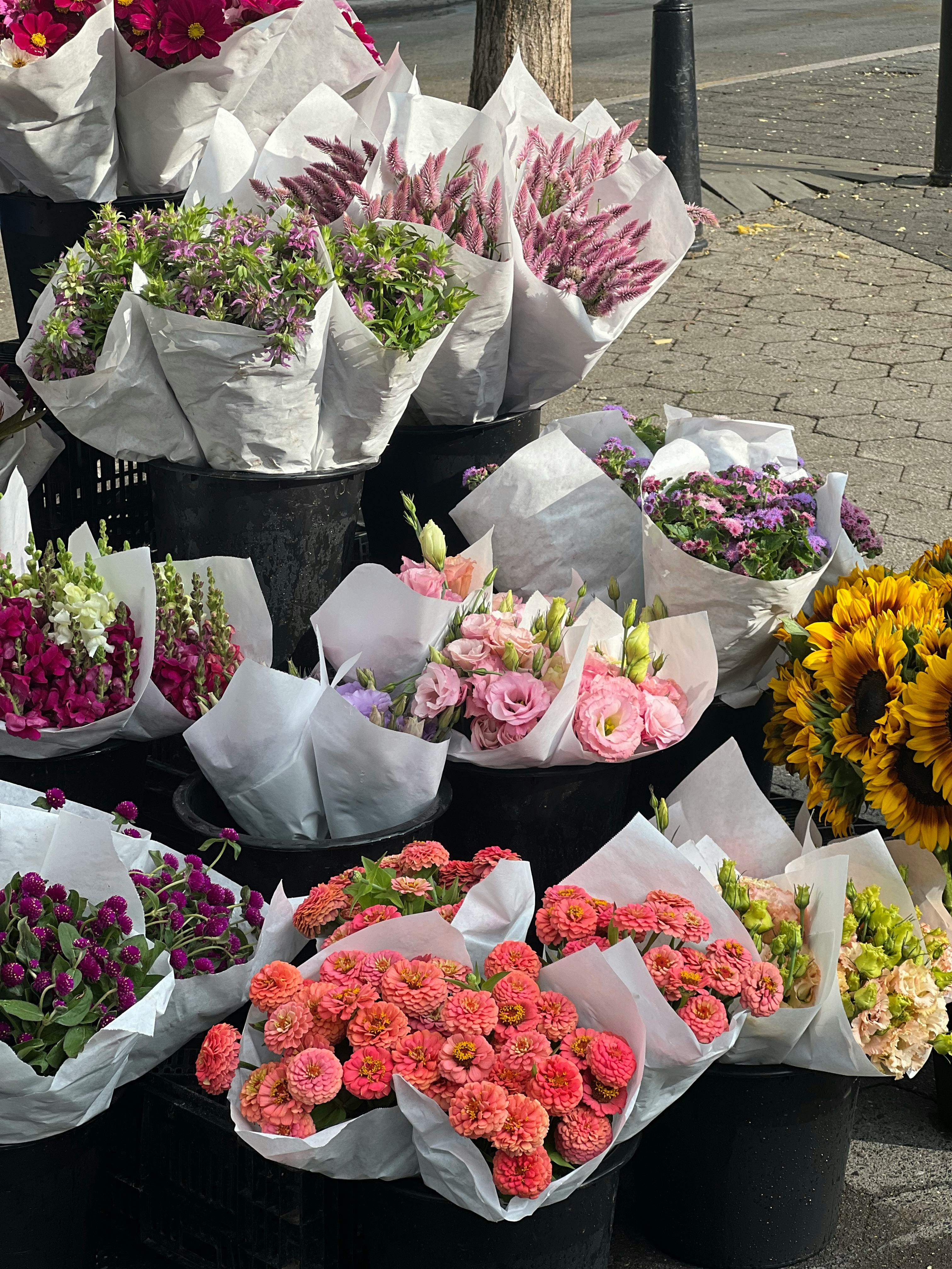 a bunch of flowers are sitting in black buckets