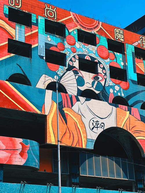 Free Vibrant mural artwork on a city street building showcasing Asian cultural elements. Stock Photo