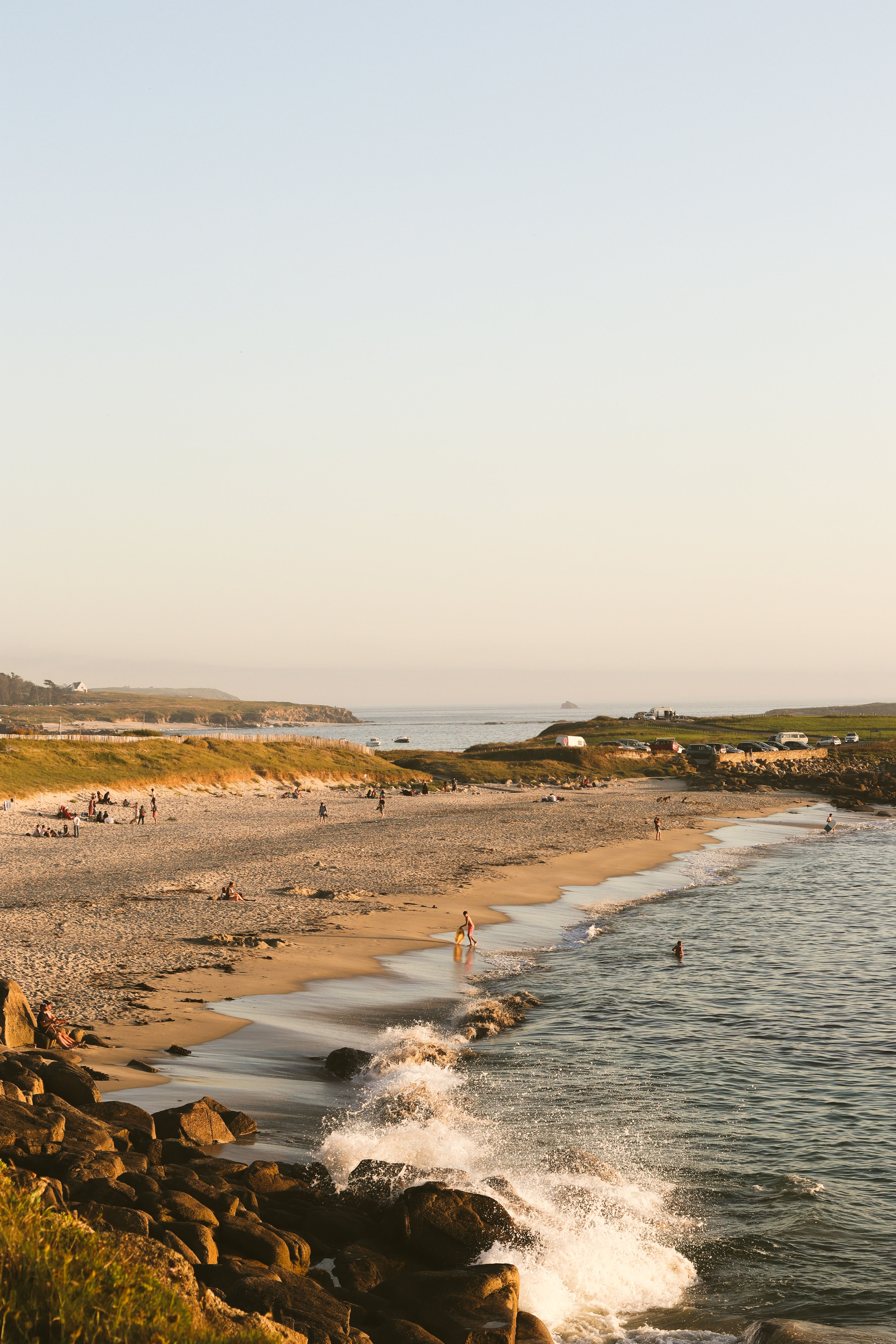 A beach with waves and people on it · Free Stock Photo