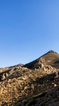 Panoramic view of a rocky mountain landscape under a clear blue sky, perfect for outdoor adventure and travel imagery.