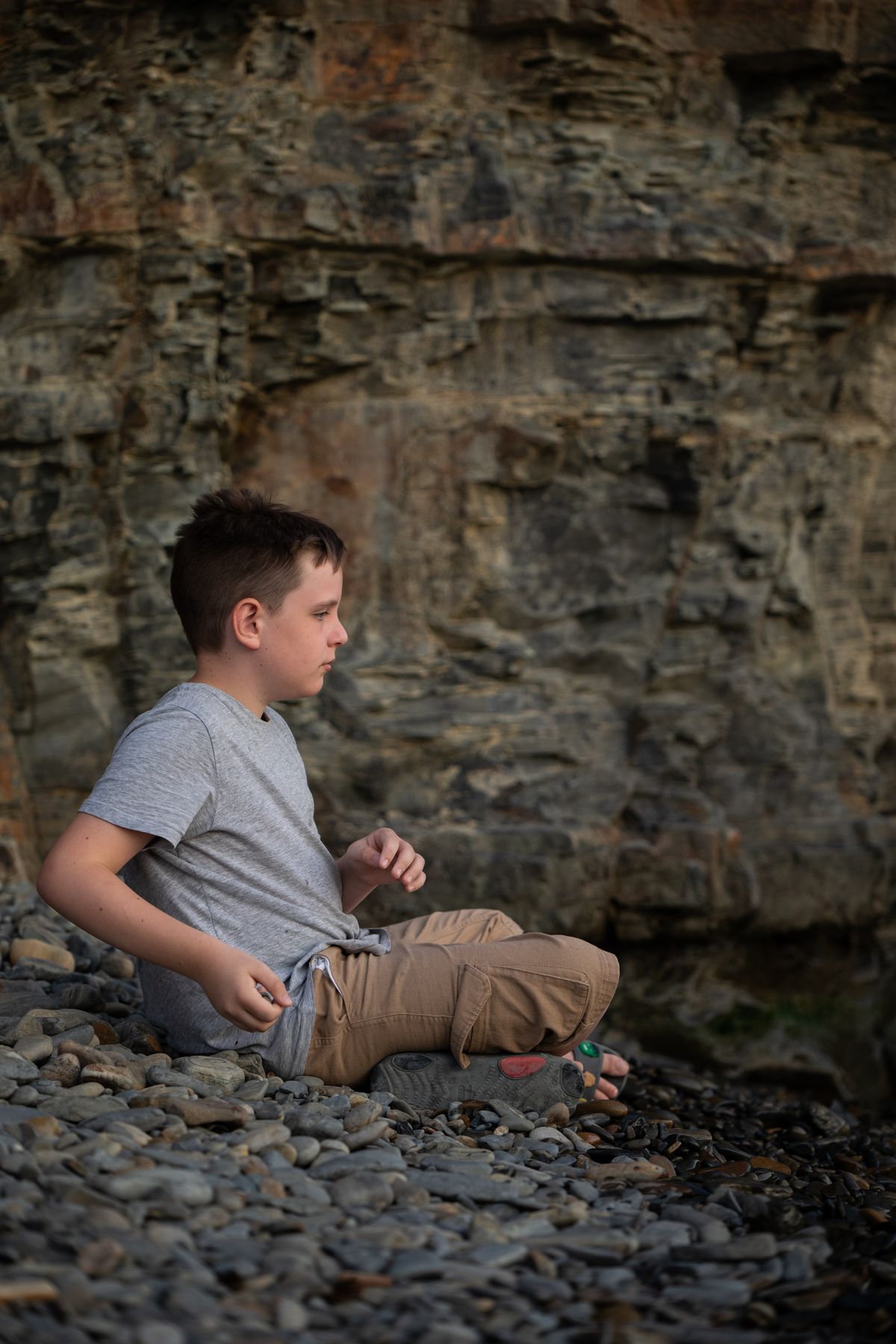 A little girl sitting on the rocks in a dress · Free Stock Photo