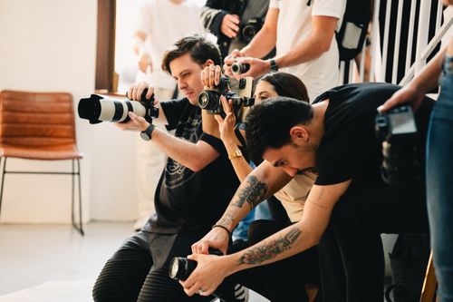 Free A lively scene of photographers working together with various cameras in an indoor setting. Stock Photo