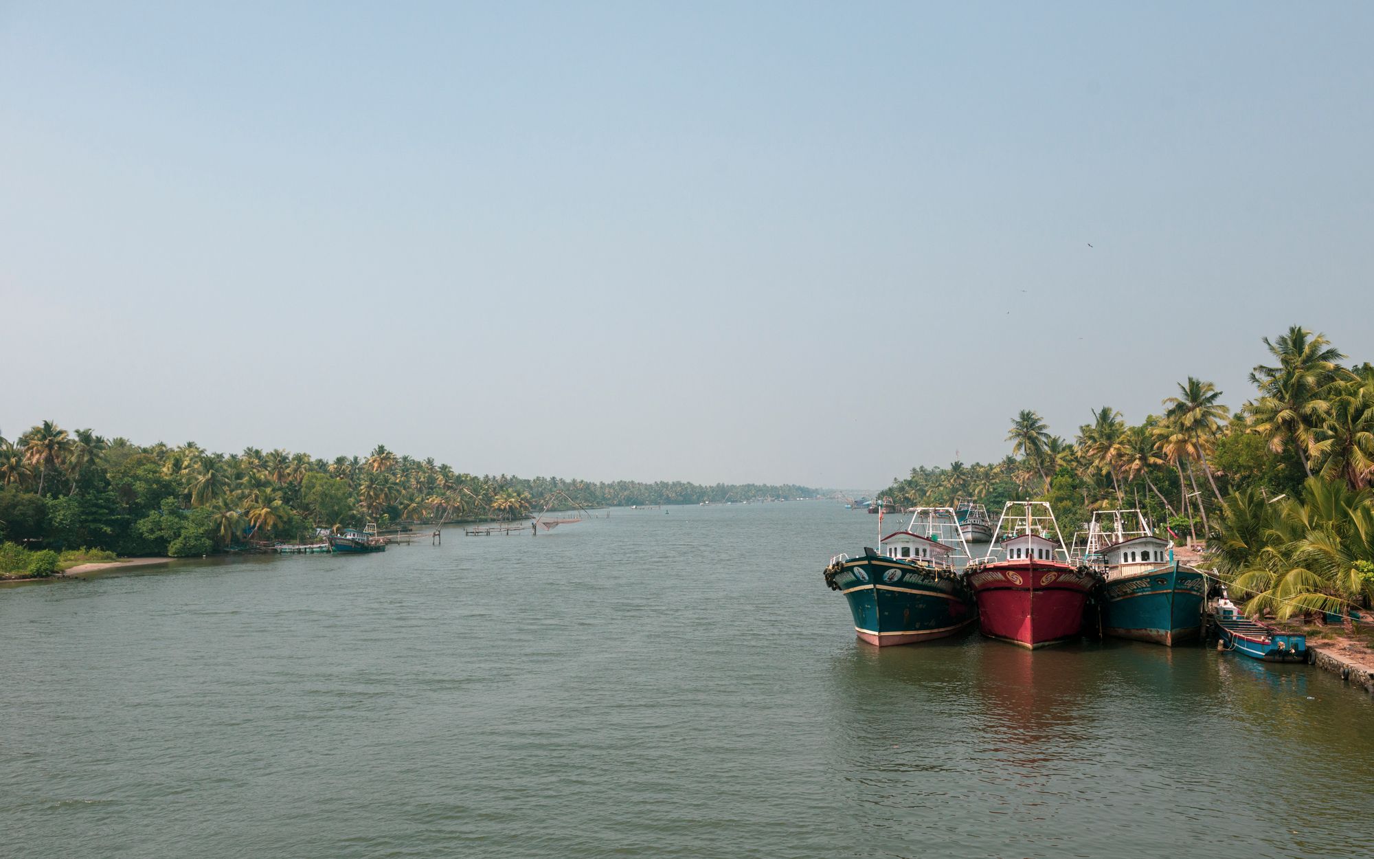 Temporary development photograph of fishing boats beside tropical backwaters in Kerala, not Mulki.