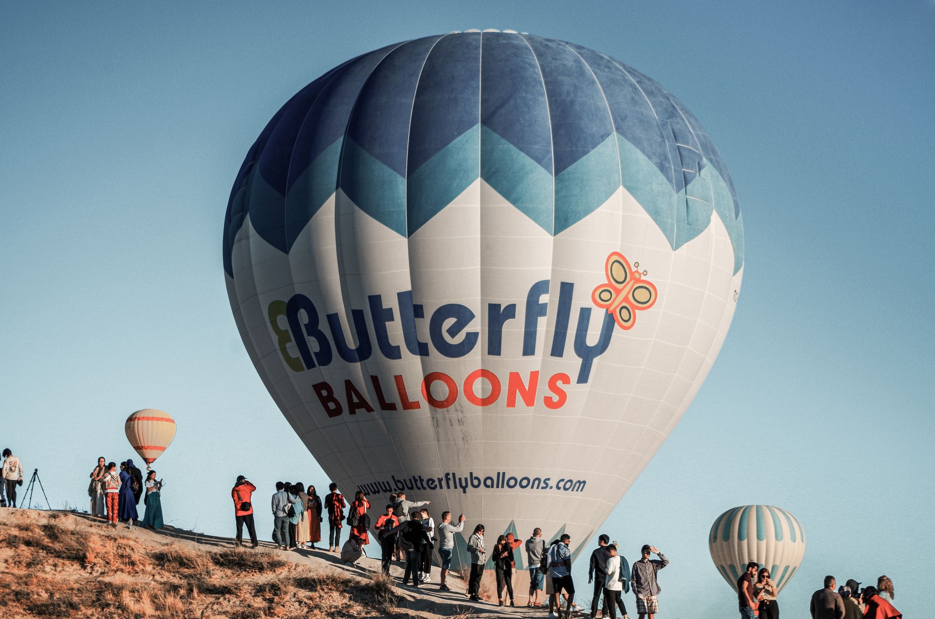 Experience a thrilling hot air balloon ride in Nevşehir, Türkiye amidst a vibrant sky.
