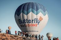 Experience a thrilling hot air balloon ride in Nevşehir, Türkiye amidst a vibrant sky.