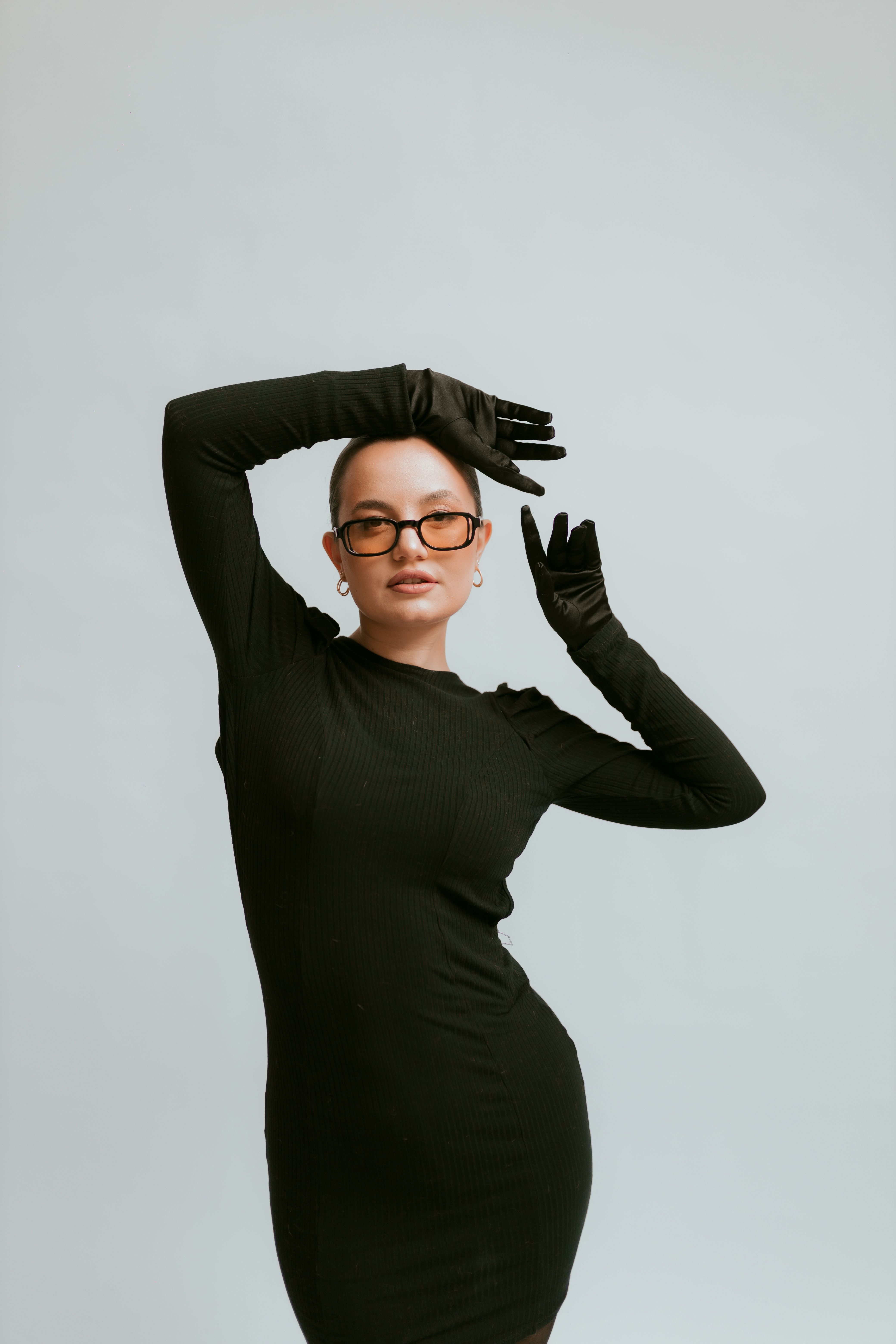 Woman with Short Hair Posing Wearing Black Gloves and Black Bodysuit Dress  with Sleeves  Free Stock Photo