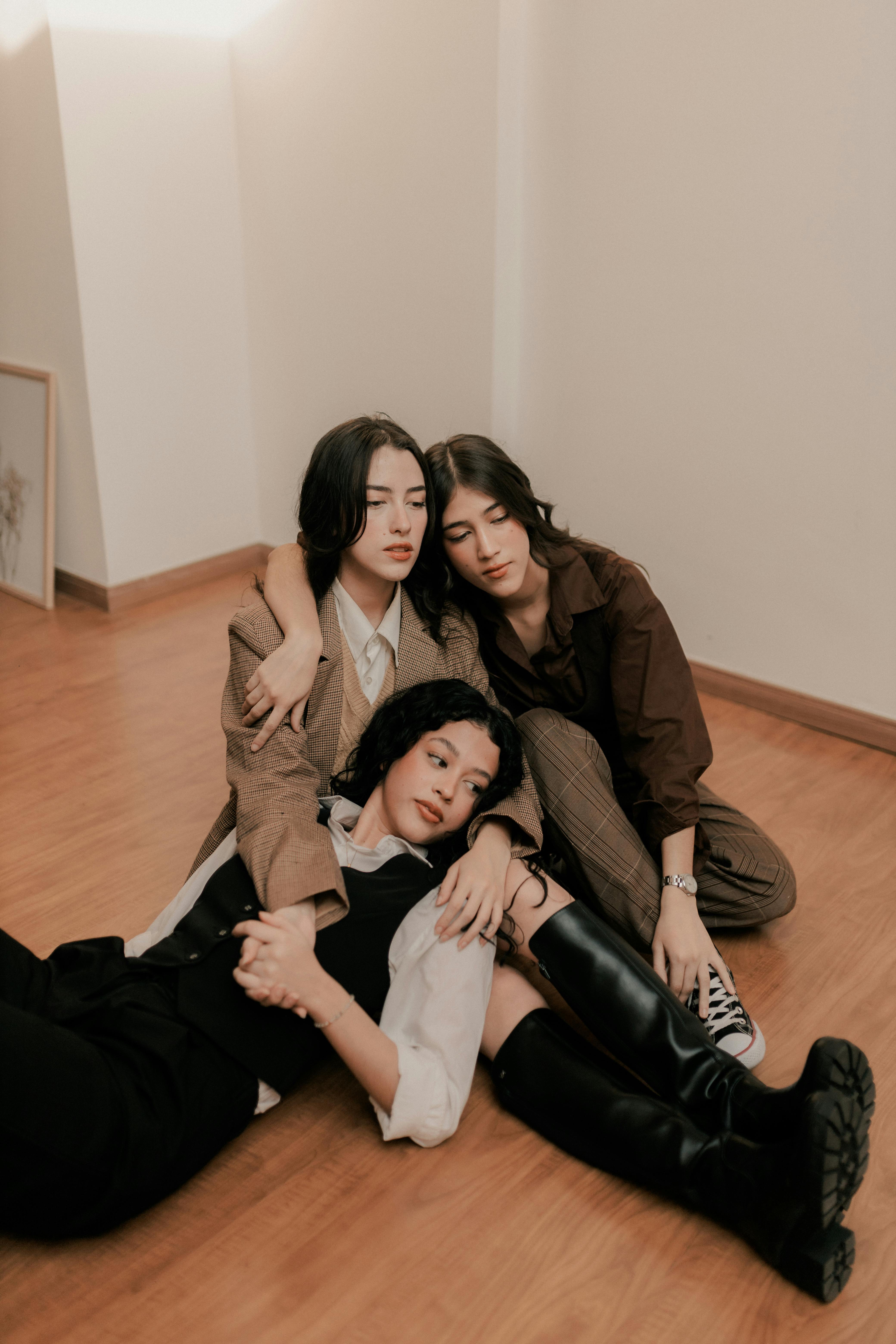 Three women laying on the floor with their arms around each other