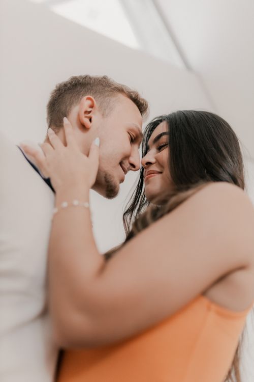 Free Close-up of a couple lovingly embracing indoors in warm daylight. Stock Photo