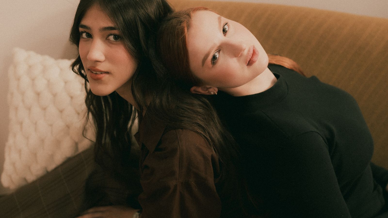 Two women seated close together on a sofa
