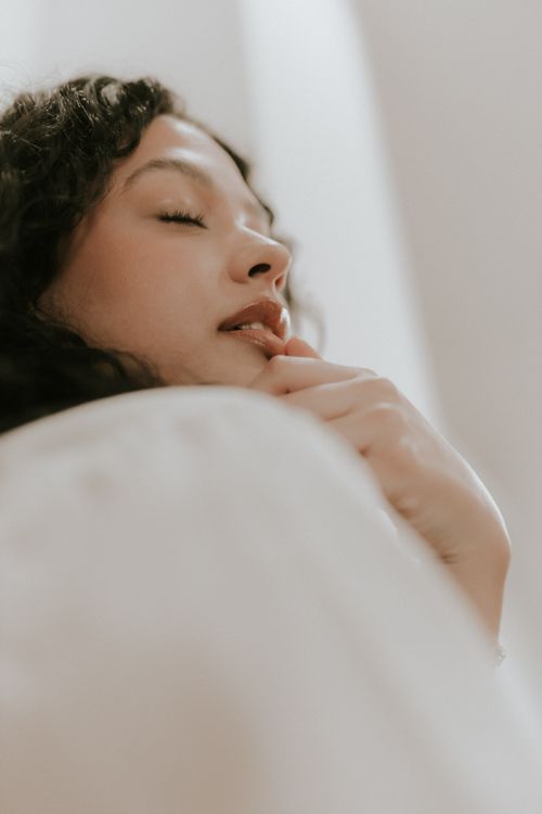 Free Close-up portrait of a relaxed woman with closed eyes indoors, captured in soft natural lighting. Stock Photo
