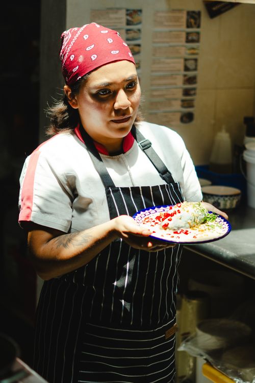 Free Chef in Lerma de Villada, Mexico, presenting a dish in a restaurant kitchen. Stock Photo