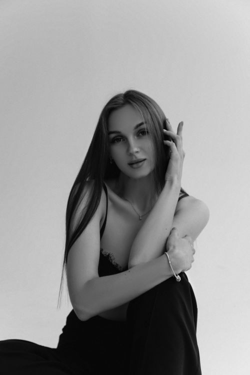Free Black and white portrait of a young woman with long hair, exuding elegance and style. Stock Photo