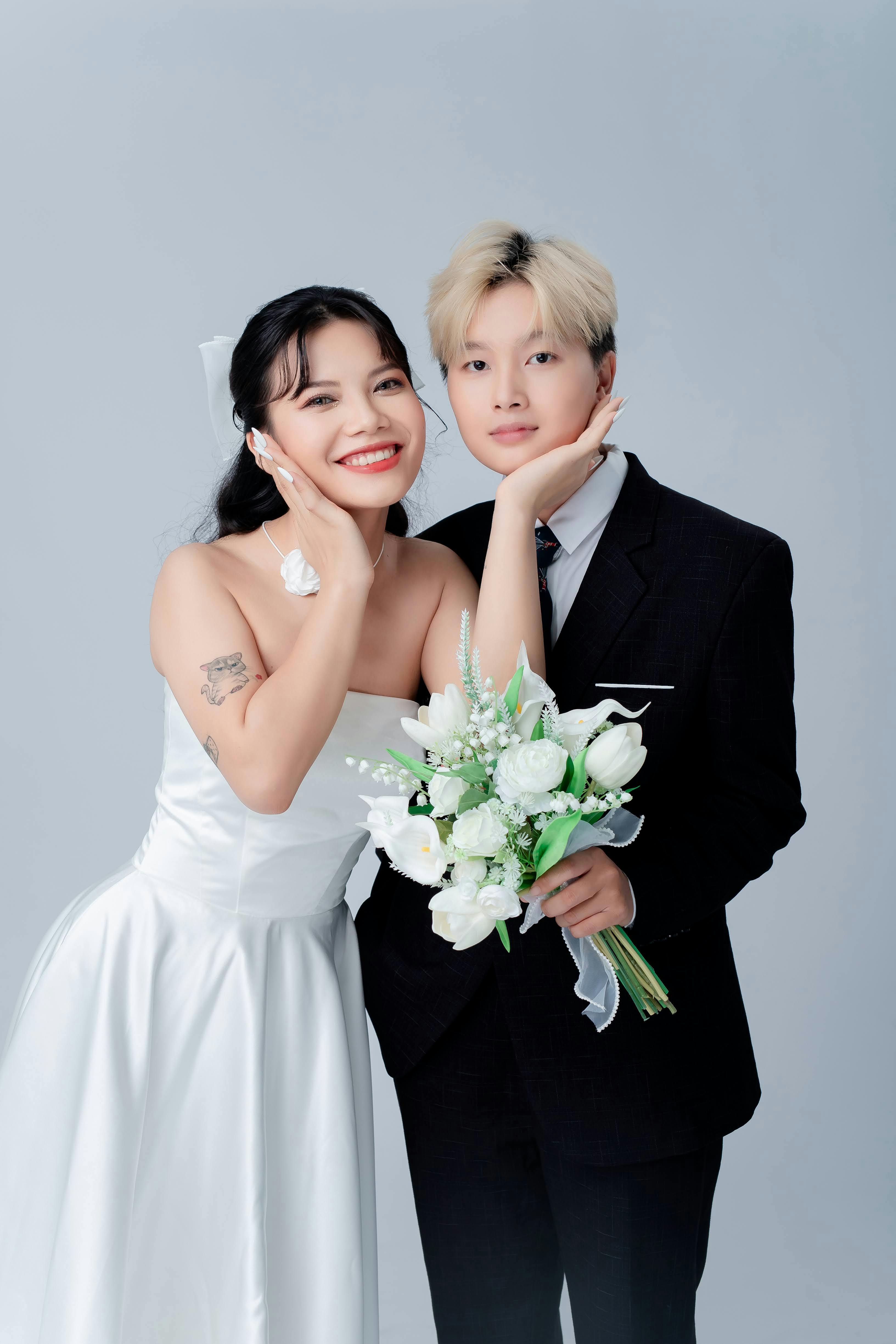 Charming wedding couple posing with a bouquet, showcasing elegance and love.