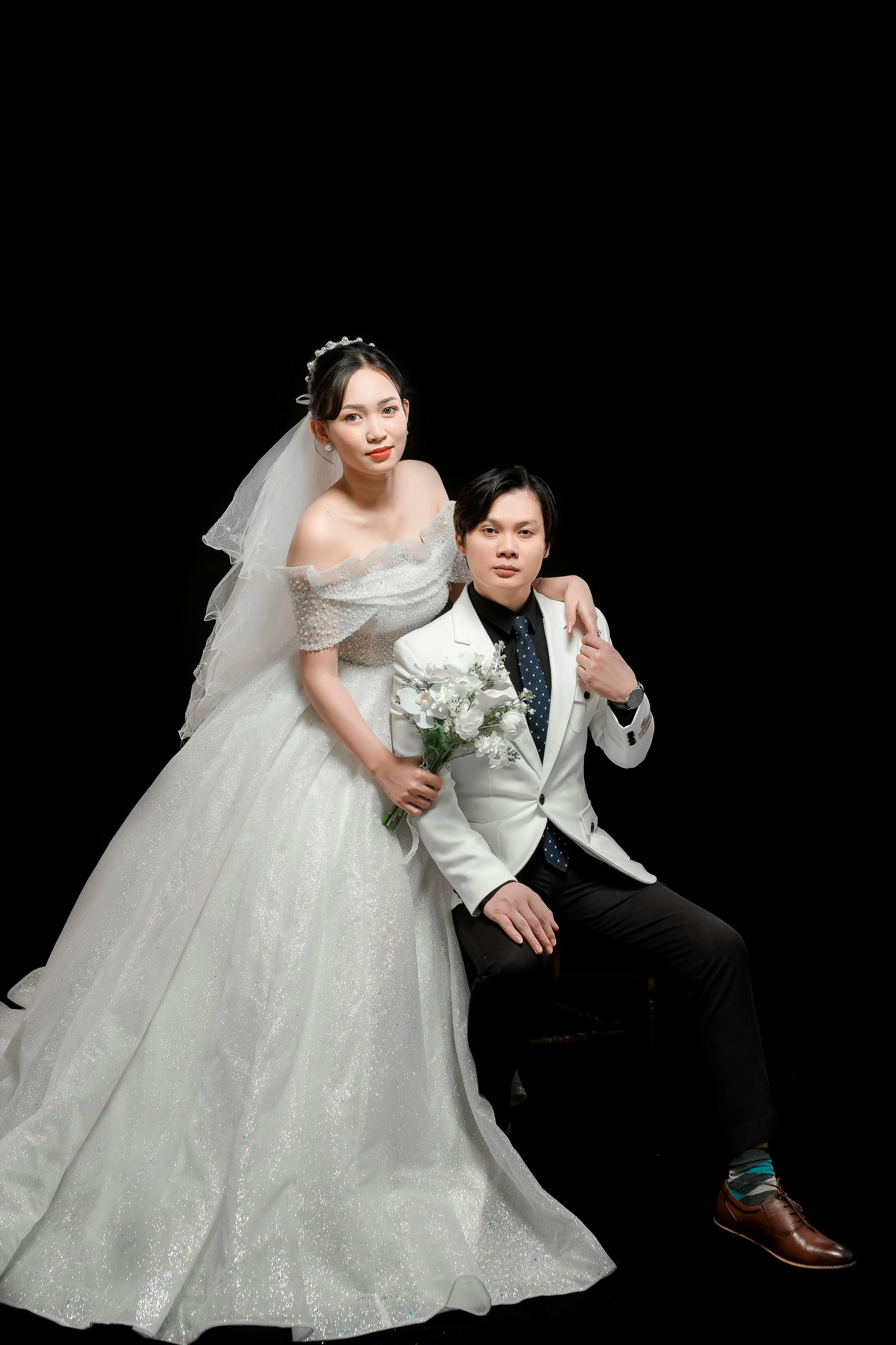 A man and woman in wedding attire pose for a photo · Free Stock Photo