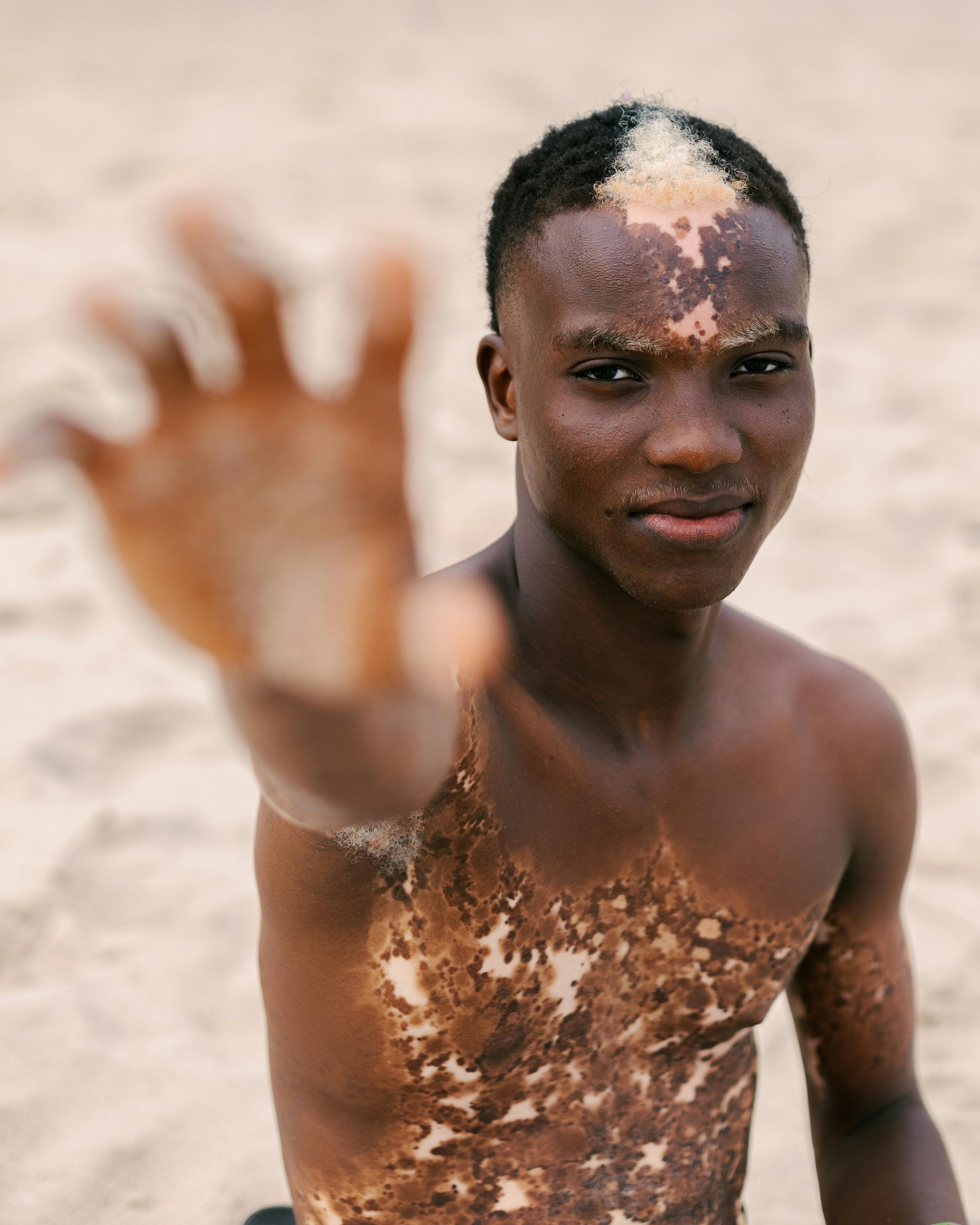 a young man with mud on his body and hands up