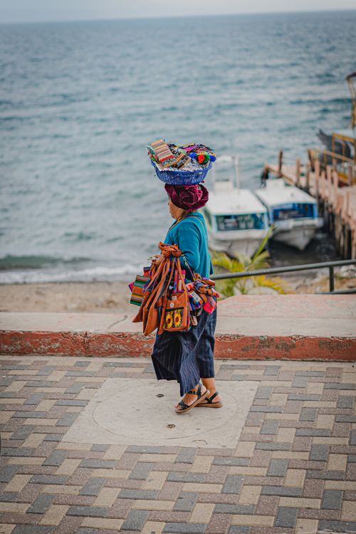 Free Woman in traditional attire sells crafts by Lake Atitlán, Panajachel, Guatemala. Stock Photo