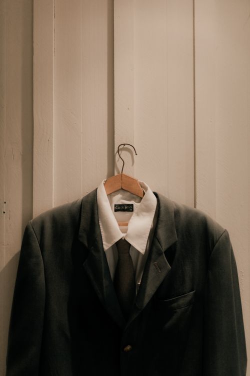 Free Vintage menswear ensemble with jacket and tie on a hanger indoors. Stock Photo