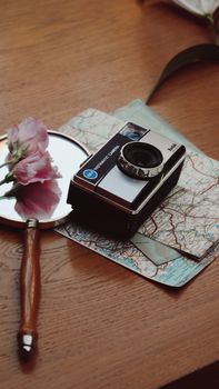 Explore nostalgia with a vintage camera, map, and magnifying glass on a wooden table.