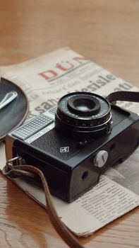 A classic vintage camera placed on an old newspaper with a retro vibe.