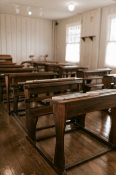 Empty vintage classroom with wooden desks, capturing a nostalgic educational atmosphere. — photo by Alexander Mass