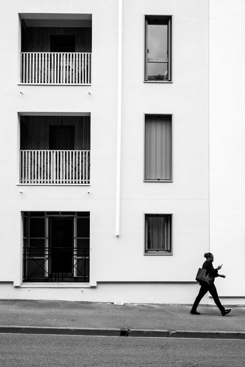 A man walking down the street in front of a building · Free Stock Photo