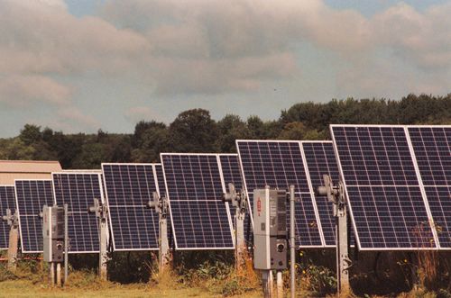 Free Solar panels in a field generating clean, renewable energy on a sunny day. Stock Photo