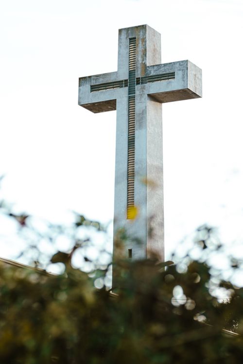 Free Tall concrete cross surrounded by foliage in Chillán, Chile under a bright sky. Stock Photo