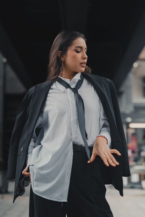 Free Confident woman in business attire making a statement in an urban scene. Stock Photo