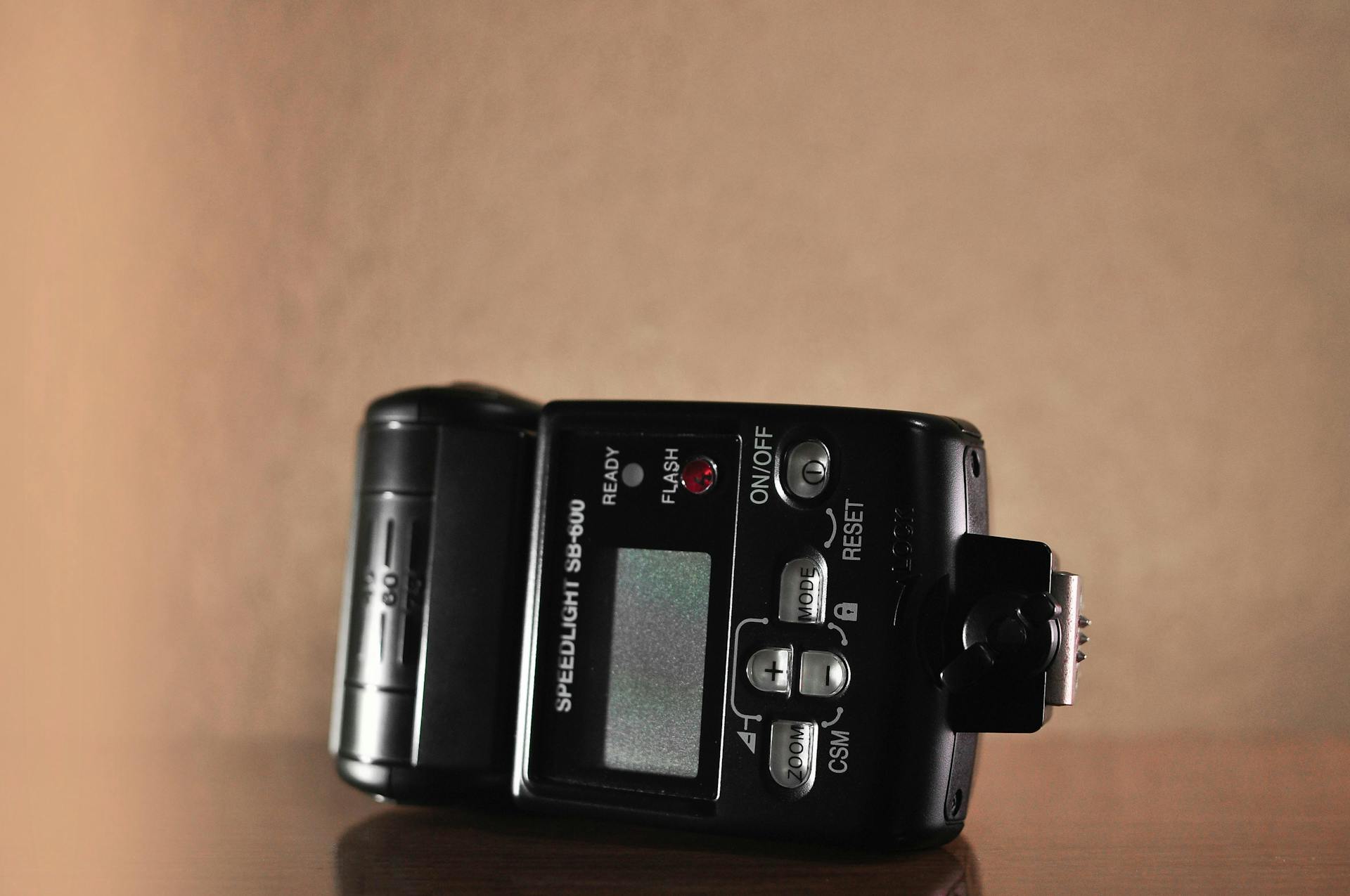 An SB-600 speedlight flash unit with display, buttons, and interface.