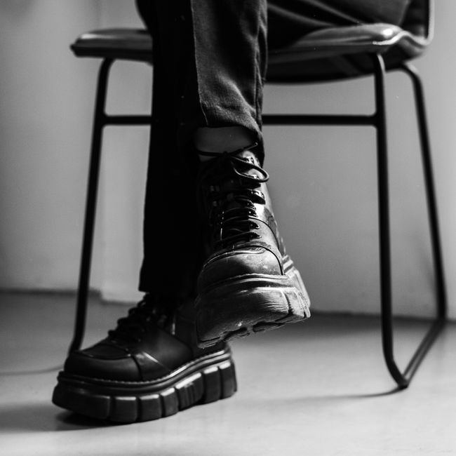 Close-up of boots and legs in a dramatic black and white photo, exuding style.