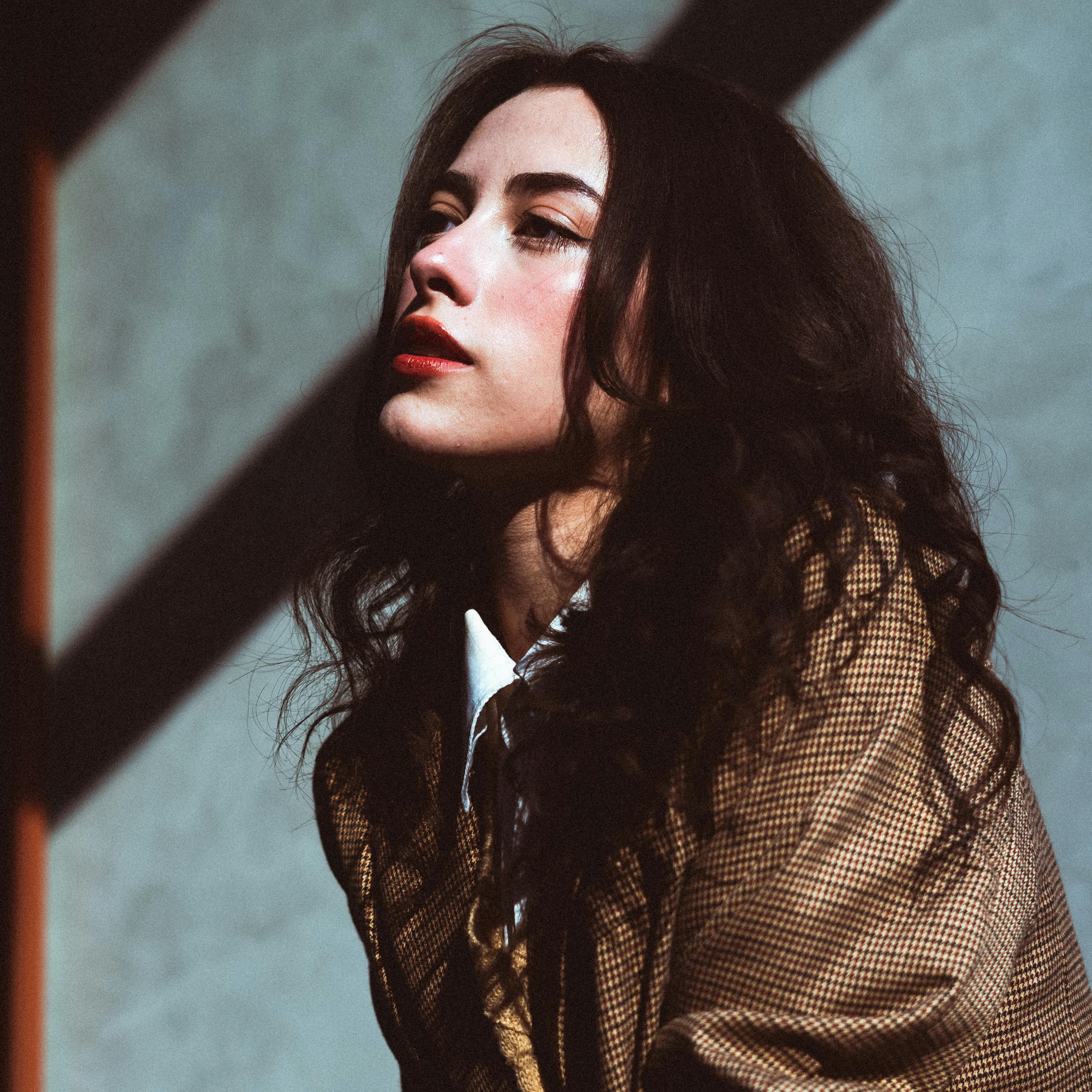 Striking portrait of a woman with long hair in dramatic lighting and shadows.