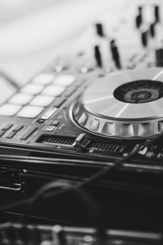 Black and white close-up of a DJ mixer with turntables, capturing the essence of music technology.