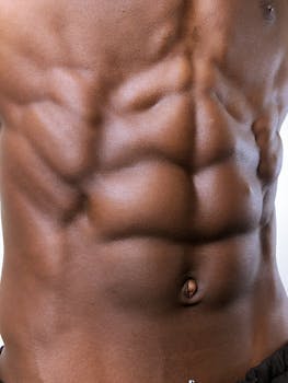Photograph highlighting a muscular male torso with defined abs, showcasing physical fitness and strength.
