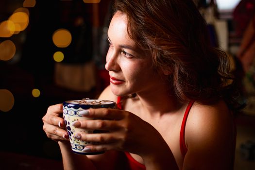 Woman in a warm setting enjoying coffee, creating a relaxing mood.