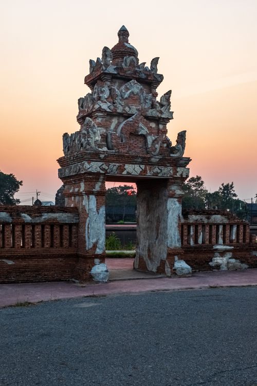 Free A beautifully detailed brick temple gate in Bangkok at sunrise, showcasing traditional Thai architecture. Stock Photo