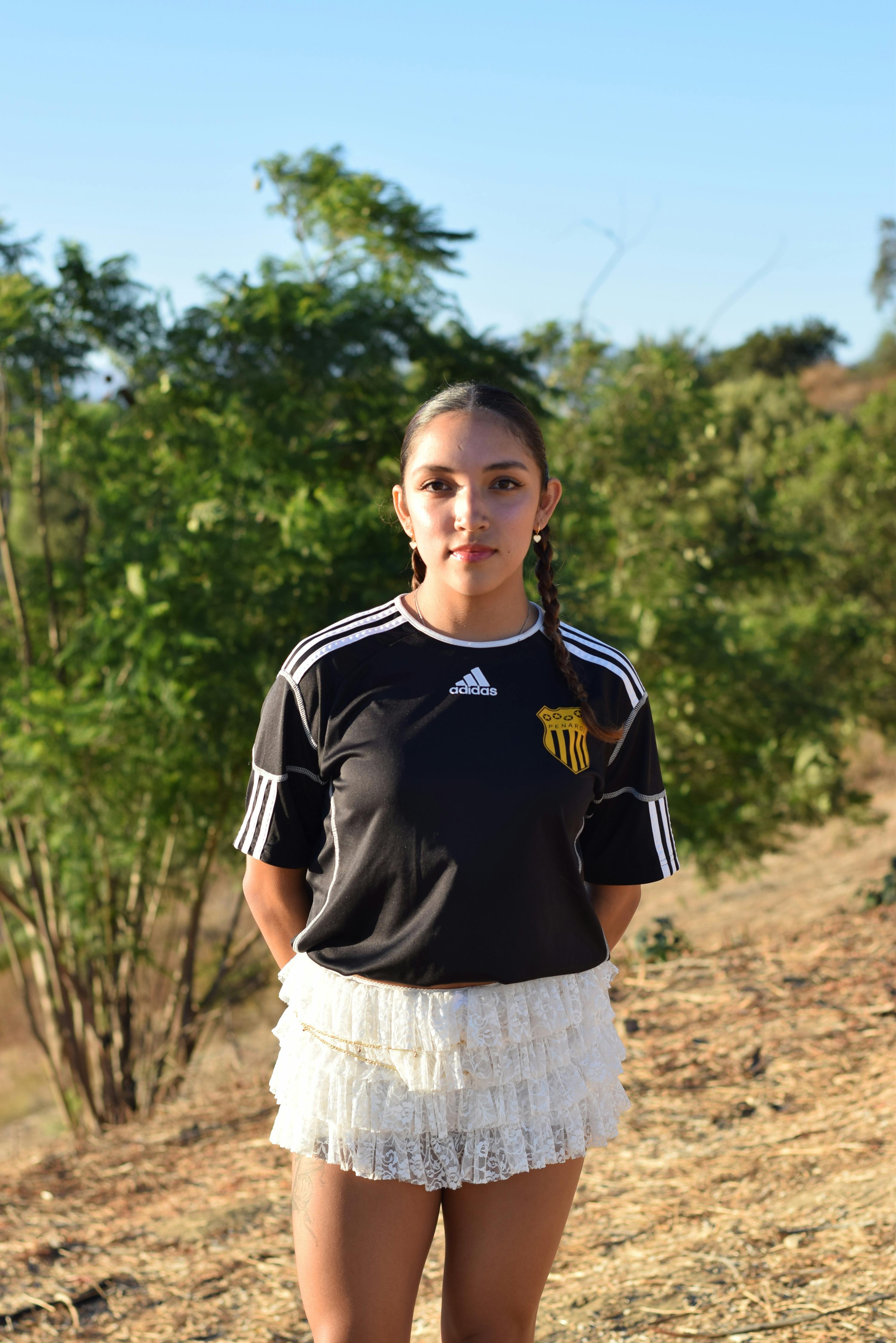 Young girl wearing a soccer jersey outdoors, enjoying a sunny day. Perfect for lifestyle and sports imagery.