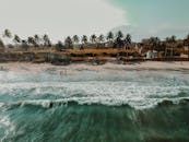 日落时分，从空中俯瞰加纳阿克拉热带海滩的棕榈树，景色令人惊叹