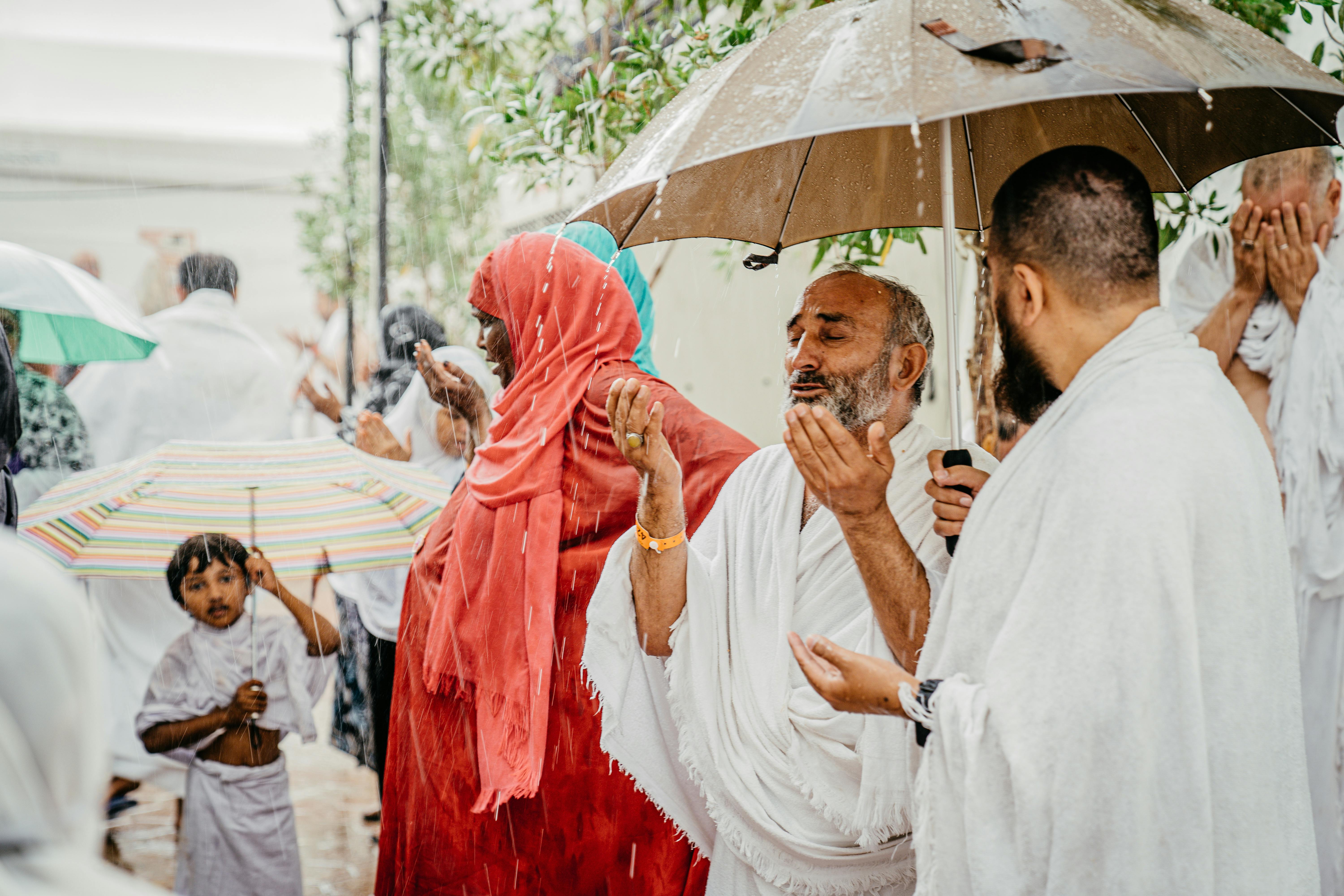 A religious group engages in prayer during rain, illustrating devotion and cultural traditions.