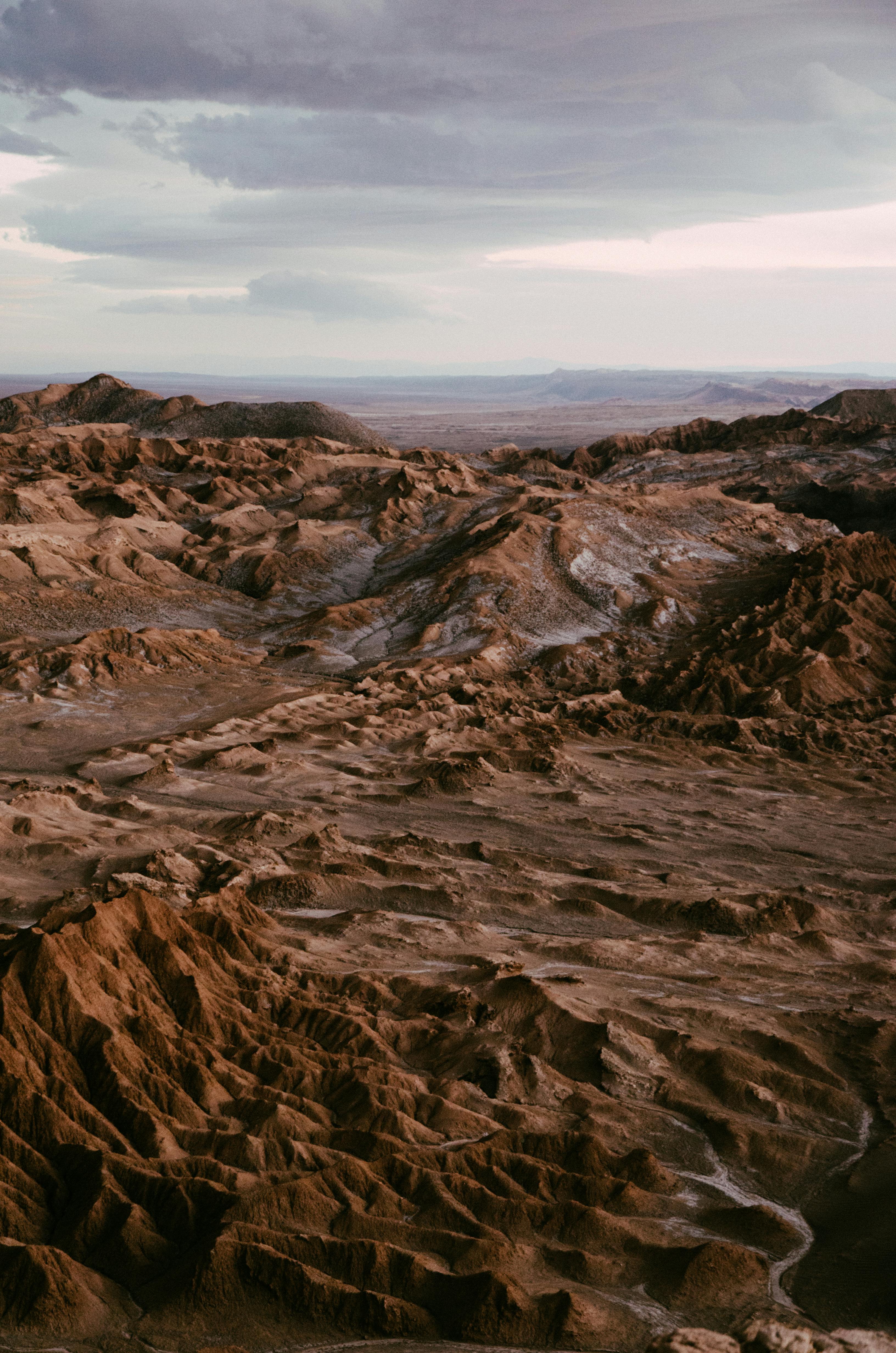 A breathtaking view of the Atacama Desert landscape during twilight, showcasing unique rock formations.