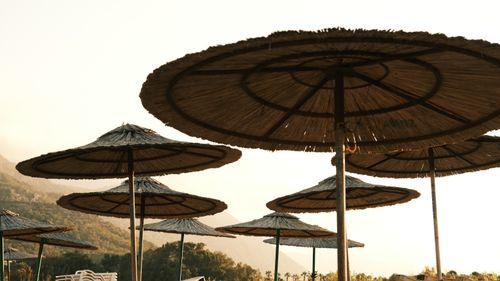Free Scenic view of tropical beach umbrellas with a sunset backdrop, perfect for a summer vacation vibe. Stock Photo