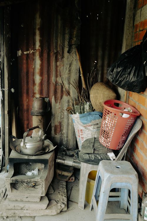 Free A rustic corner in Tien Giang, Vietnam featuring an old stove, tools, and household items. Stock Photo