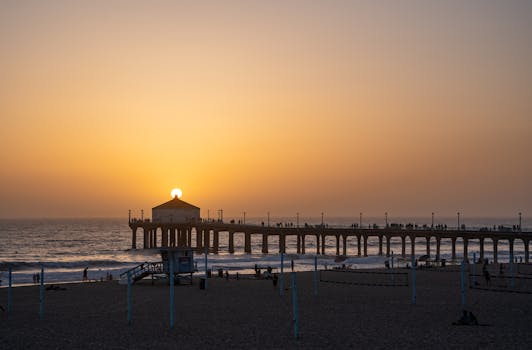 Capture of the sunset at Manhattan Beach Pier with silhouettes and warm hues.