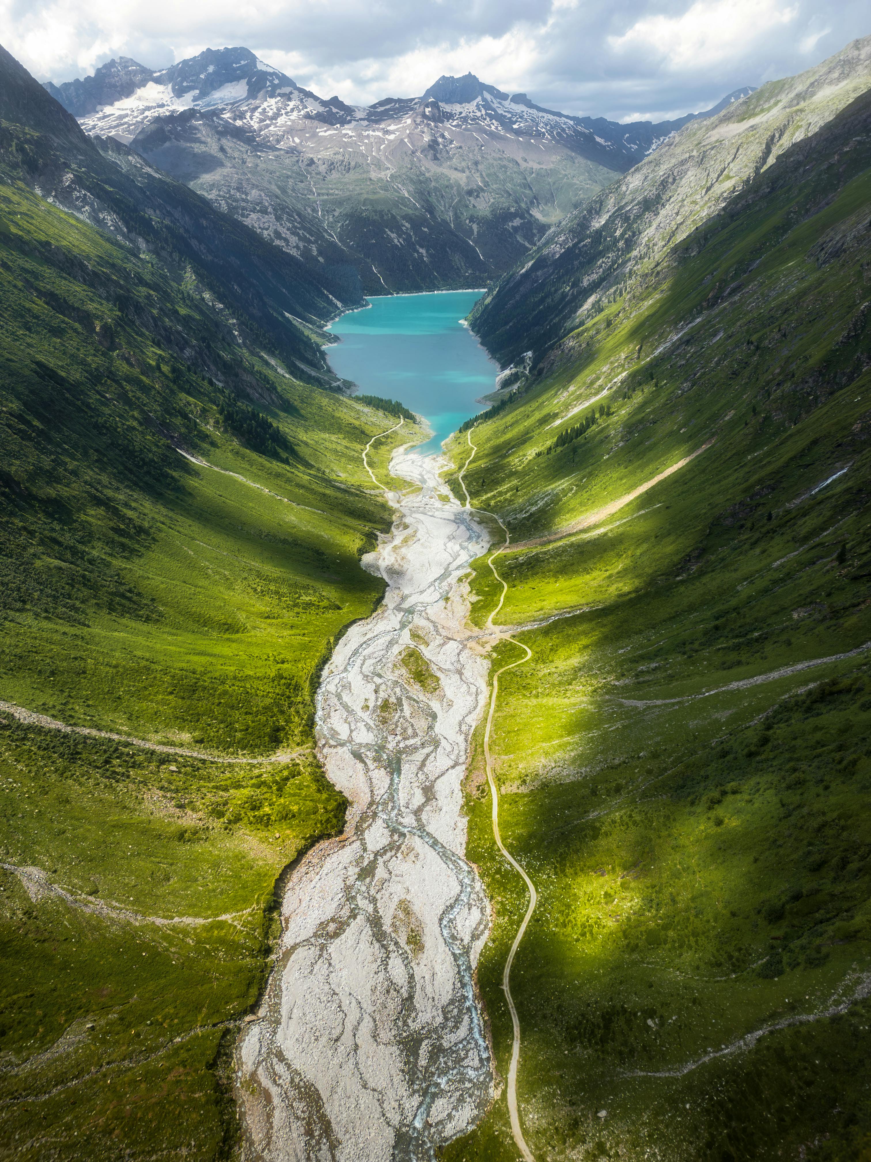 Breathtaking aerial photo of a serene lake and surrounding lush valley in Austria.