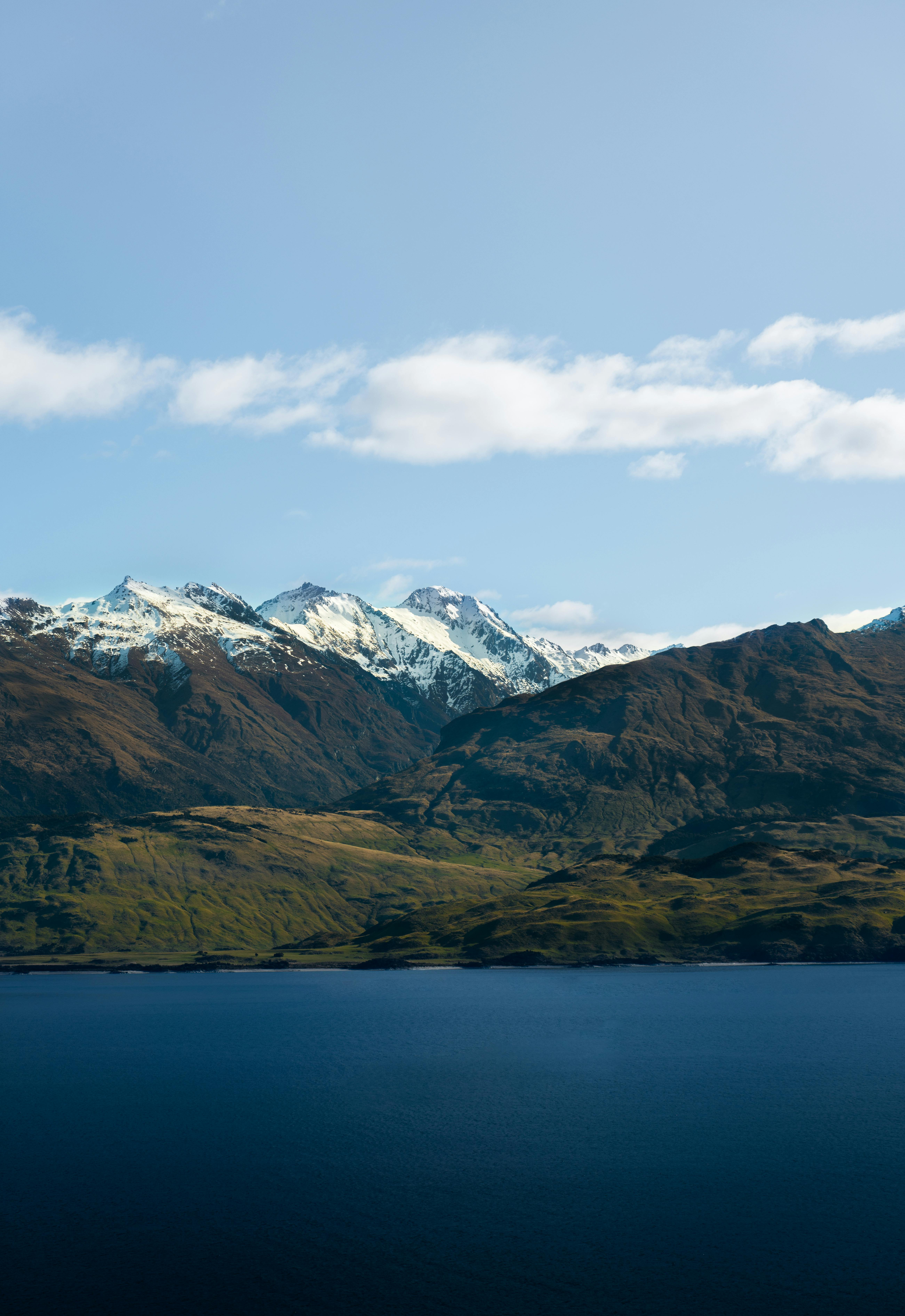 Breathtaking view of snow-capped mountains and a serene lake captured in New Zealand, illustrating nature's majesty.