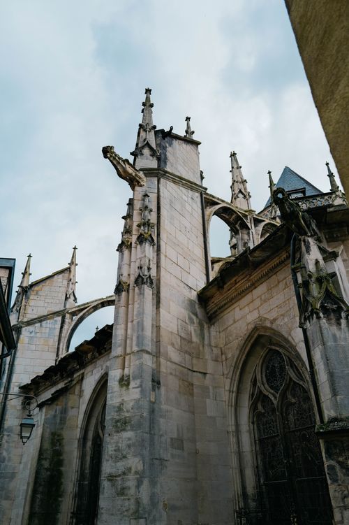 Free A detailed view of a gothic cathedral facade and stone gargoyles under daylight skies. Stock Photo