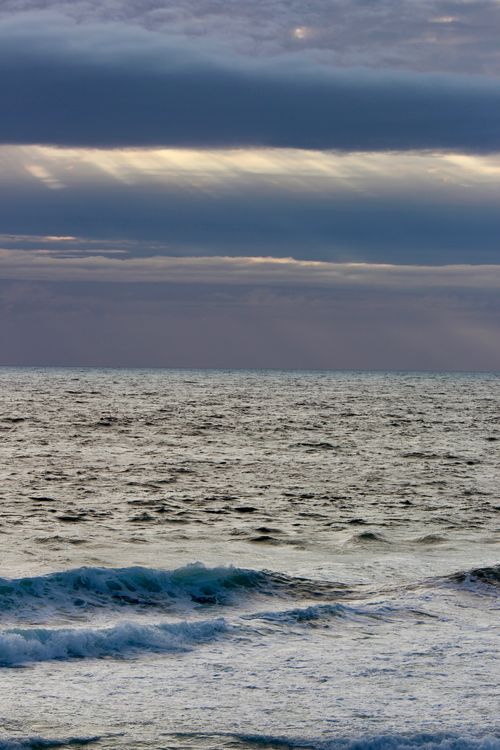 Free A captivating seascape capturing waves under a dramatic cloudy sky during twilight. Stock Photo
