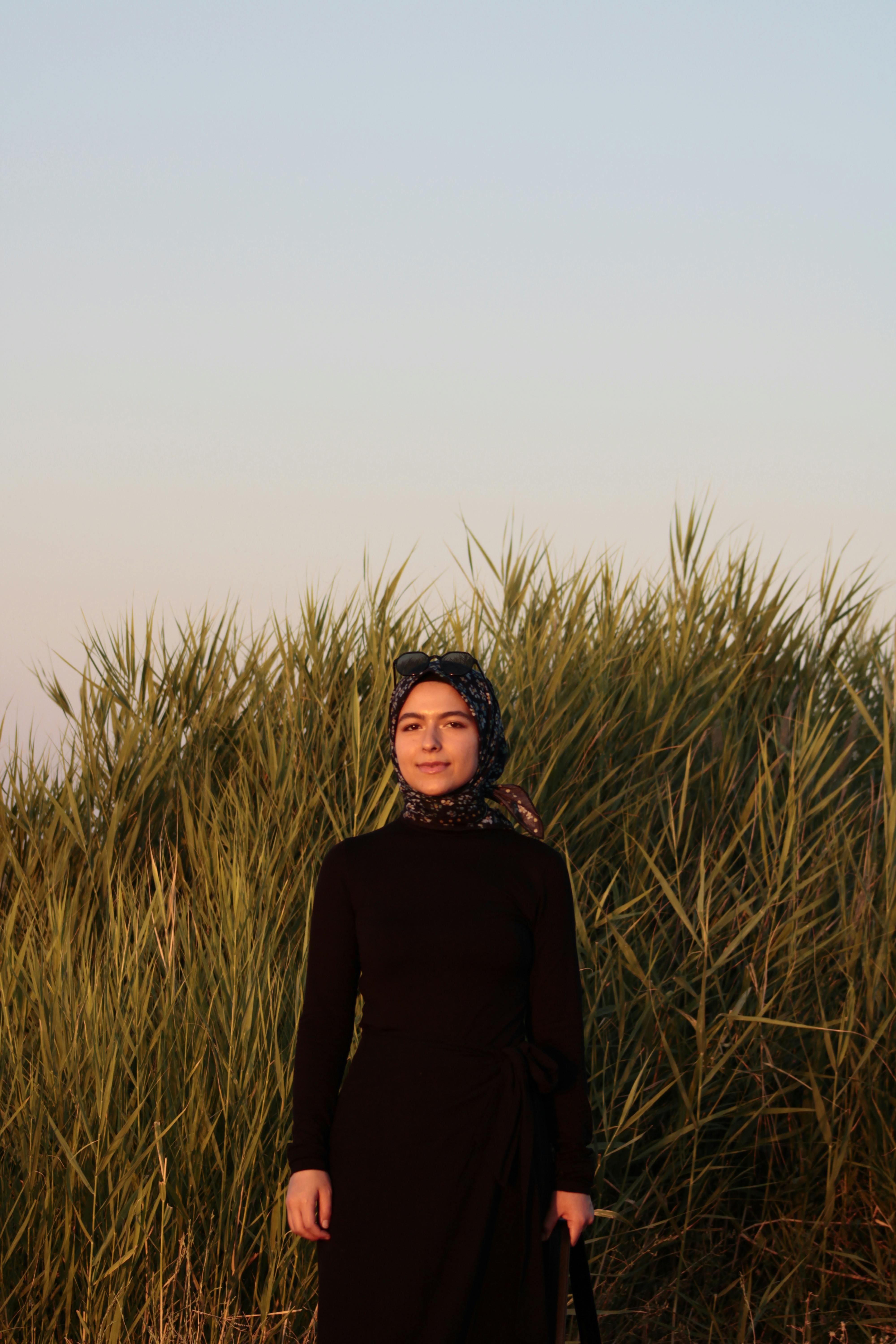 Portrait of a young woman in a field at sunset, showcasing natural beauty and serenity.