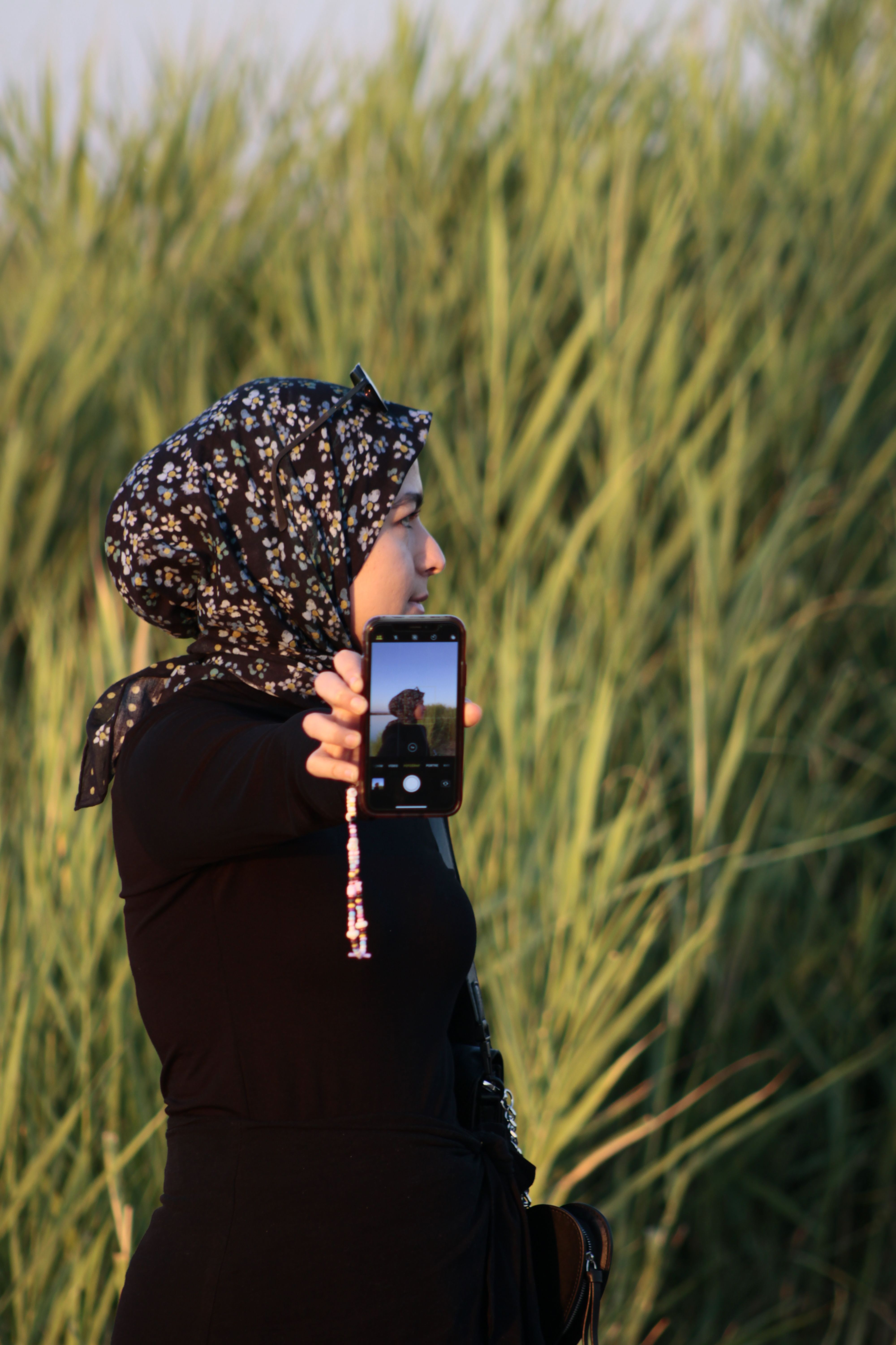 A woman in a hijab taking a picture of herself · Free Stock Photo